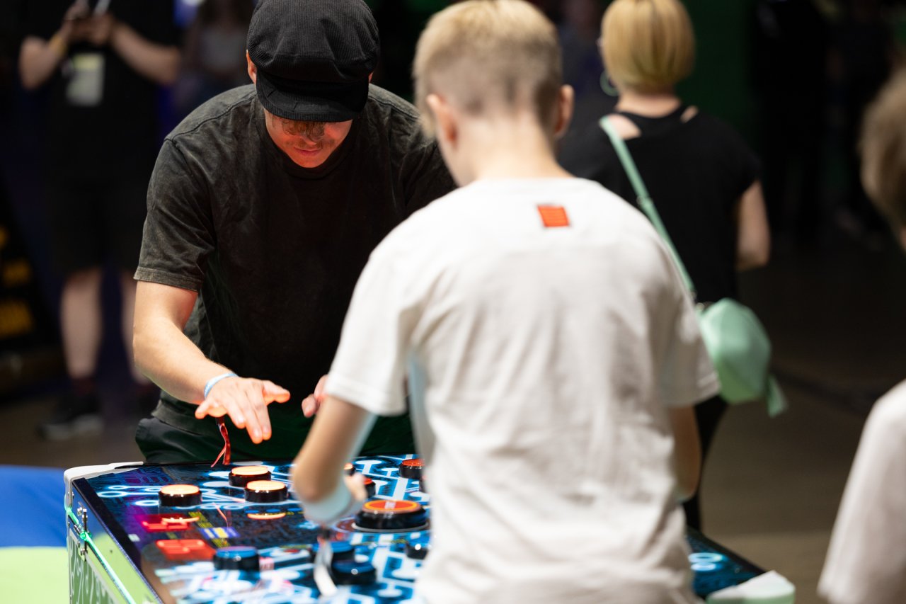 Tubettaja Herbalisti pelaa Neuron Race -nopeuspeliä selin kameraan olevaa lasta vastaan.